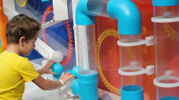 Fascinující fyzika s labyrintem trubek. Prováděním experimentů dítě získá praktické dovednosti a pochopí, že učení je zábava. — Stock video