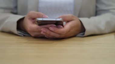 Sosyal medya ağlarında akıllı telefondan yazı yazan bir iş kadını. Kadın elleri cep telefonlu mesajlar tutuyor müşterilerle internet üzerinden iletişim kuruyor.