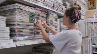 09.05.2021 - Moskova, Rusya - bir sanat mağazasındaki kadın sanatçı ürünleri seçiyor. Modern kadın süpermarketten alışveriş yapıyor..