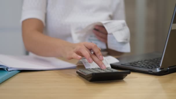 Vrouw berekenen maandelijkse huiskosten, belasting, bankrekening saldo en credit card rekeningen betaling. Vrouw met rekeningen en rekenmachine. — Stockvideo