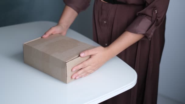 Kvinna öppnar paket inomhus. kvinna öppna och packa upp pappkartong paket i vardagsrummet hemma. god leveransservice. — Stockvideo