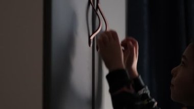 Karanlık bir odada küçük bir çocuk bir gardırop açıyor. Çocuk gizli bir hediye arıyor.