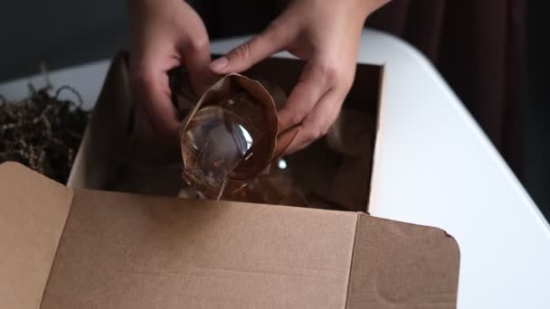 Γυναίκα ανοίγει ένα κουτί παράδοσης από ένα κατάστημα και ανακαλύπτει ένα σπασμένο γυαλί. Ένα αντικανονικά συσκευασμένο αντικείμενο συνετρίβη κατά την παράδοση — Αρχείο Βίντεο