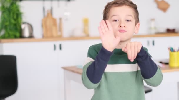 Joyeux garçon agitant les mains devant la caméra. bonne humeur à la maison — Video