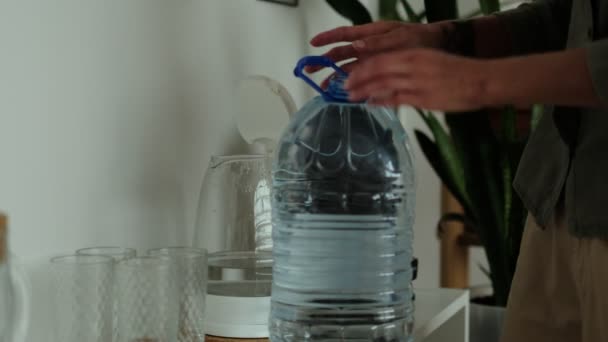 Las manos de mujer vierten el agua de una botella de plástico en la tetera, hervidor de agua. agua potable — Vídeos de Stock