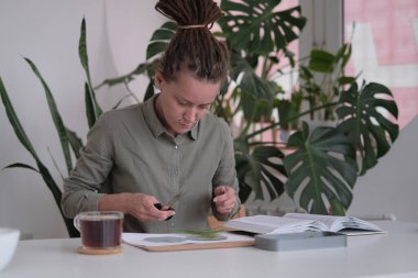 Kadın cam levhaları tamir ediyor. Kurumuş çiçek resmi. Herbaryum ile mozaik cam tekniğinde usta sınıf..