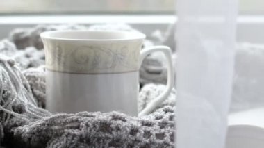 Bir fincan kahve ve bir kitapla rahat bir ev. Hygge tarzı. Tahta tahtada sıcak atkı ile sarılmış siyah kahve bardağı. Üst görünüm, vintage tarzı, Natürmort.