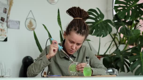 Žena opravuje skleněné talíře. Obrázek sušených květin. Mistrovská třída na vytváření rámu s herbářem v tiffany technice v barevném skle. — Stock video