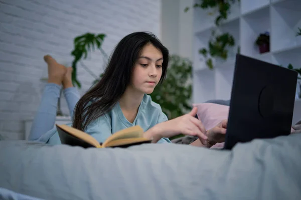 Tinédzser lány házi feladatot csinál az ágyon. tini lány iskolás diák írni jegyzetek videó online webinar tanulni laptop. távoktatási kurzus videokonferencia pc call. — Stock Fotó