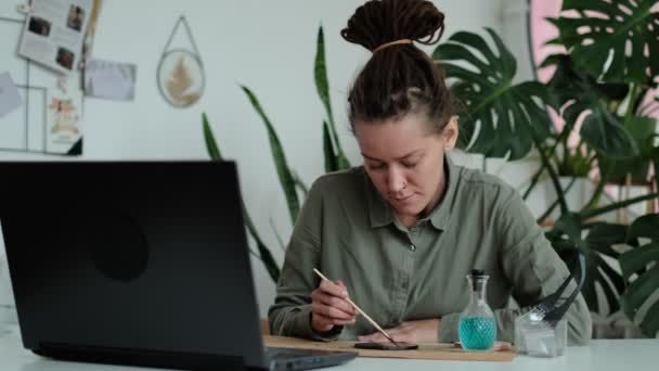 Kobieta naprawia szklane talerze. Obraz suszonych kwiatów. Master klasy na tworzenie ramki z Herbarium w Tiffany techniki w witrażu. — Wideo stockowe