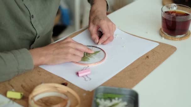 Женщина чинит стеклянные тарелки. Картина сушеных цветов. Мастер-класс по созданию каркаса с гербарием в технике тиффани из витража. — стоковое видео