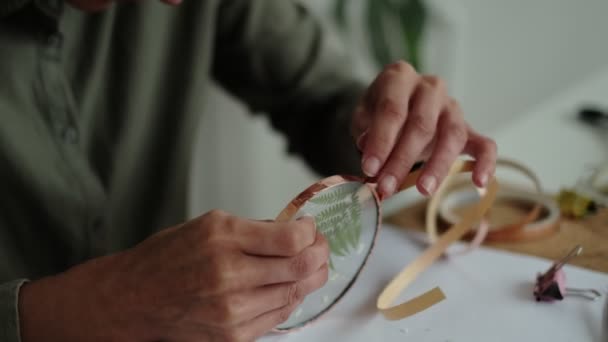 Woman fixes glass plates. A picture of dried flowers. Master class on creating frame with Herbarium in tiffany technique in stained glass. — Stock Video