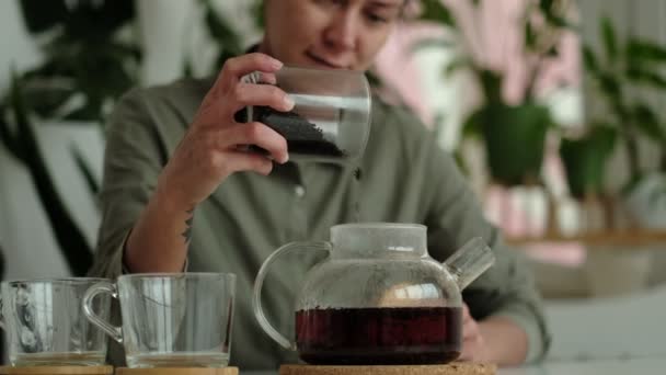 La donna in una camicia di lino versa il tè in due tazze trasparenti. concetto di ospitalità, hostess tratta gli ospiti per il tè — Video Stock