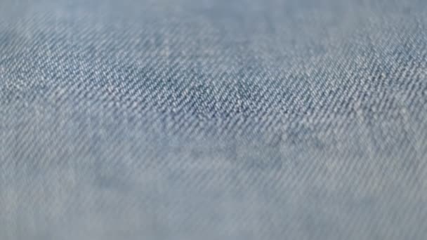 Jeans Denim Tecido Textura Close-Up. material de calça jeans jeans azul. close-up de textura de tecido material de vestuário. filmagens de vídeo — Vídeo de Stock