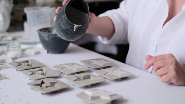 Mujer artesana vierte la mezcla de yeso en moldes de silicona. creatividad y autorrealización de una mujer moderna — Vídeo de stock