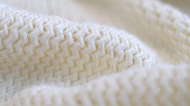 Tekstil soyut arkaplanının odaklanmasını engelle. Kıyafet endüstrisi konsepti. Dalgalı temiz malzeme. Beyaz ipliklerle örülmüş kumaş iplikleri. Örgü kumaş iplikler makro. yumuşak odaklı, seçici odaklı
