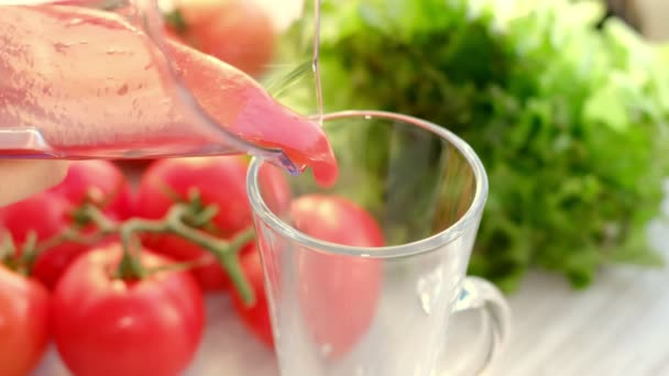 Tomato juice with sprig of tomatoes on background. Tomato juice is poured into a glass. — Vídeo de Stock