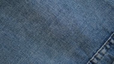 Denim Jeans Kumaş Doku Yakından. Kot pantolon kumaşı. Giysi kumaşının kumaş dokusuna yakın çekim. video kaydı