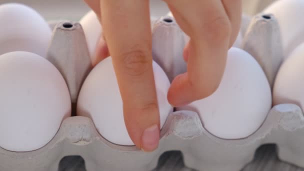 Chicken egg on the table. Easter eggs background. human hand takes one from eggs packed in carton. Close-up shooting — Stockvideo