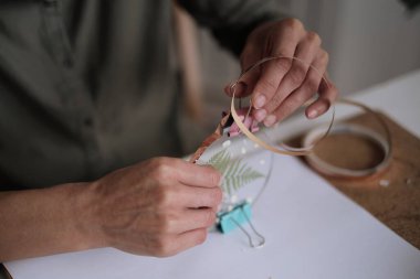 Kadın cam levhaları tamir ediyor. Kurumuş çiçek resmi. Çerçeve yaratma konusunda yüksek sınıf. Yaratıcılıkla daha ilgili ol. Mutluluk ve Tamamlanma Hayatı