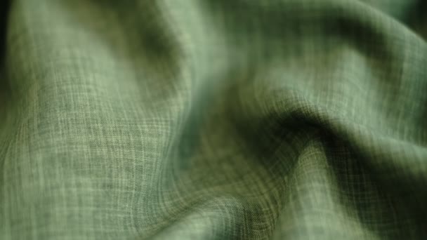 Closeup the motion footage vide. green linen textile abstract background. Clothing industry concept. Wavy material. velours fabric threads macro. Side view. Close-up shooting stock footage — Vídeo de Stock