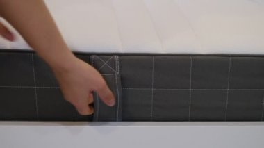 Kadın iyi bir uyku için yeni bir yatak seçiyor. Kadının eli yatak kalitesini test ediyor. Yumuşaklığı kontrol ediyorum. En iyi tip ve kalitede bir seçim. Yan görüş. Yakın çekim..