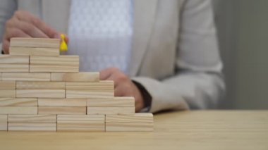 Kadın tüm basamakları atlar ve figürü merdivenin en başına koyar. Kariyer geliştirme konsepti. Başarılı bir işçinin terfisi.