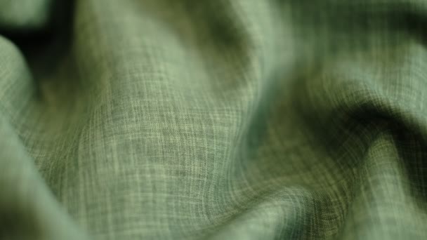 Sluit de beelden van de beweging af. groen linnen textiel abstracte achtergrond. Kleding industrie concept. Walgelijk materiaal. velours stof draden macro. Zijaanzicht. Voorgrondbeelden van close-ups — Stockvideo