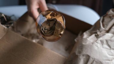 Kadın içeride paket açıyor. Kadın, evdeki oturma odasında karton kutuları açıp açıyor. iyi dağıtım servisi.