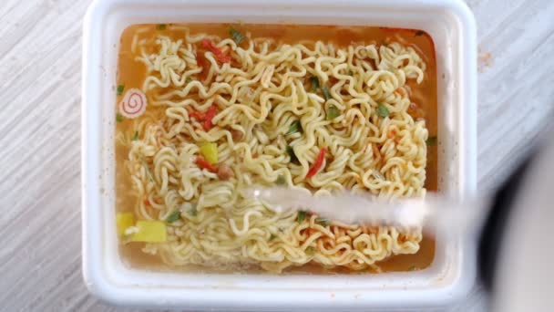 Instant Ramen Noodles in a Cup. Quick cooking instant ramen noodle soup with vegetables. Pouring water in dry noodles. Brewing noodles — Stockvideo