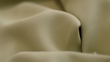 closeup the motion footage vide. green textile abstract background. Clothing industry concept. Wavy material. velours fabric threads macro. Side view. Close-up shooting stock footage