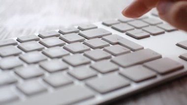 Finger pressing an enter key. Computer user hitting the enter key, up close. Confirmation, sending a message