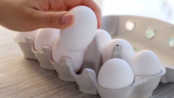 Chicken egg on the table. Easter eggs background. human hand takes one from eggs packed in carton. Close-up shooting — 图库视频影像