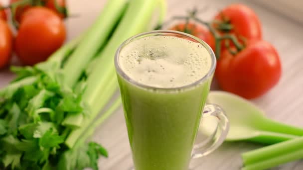 Slow motion video chia seeds pour into a glass of celery smoothie, with sprig of tomatoes on background. Healthy Vegan Green celery Smoothie. — 图库视频影像