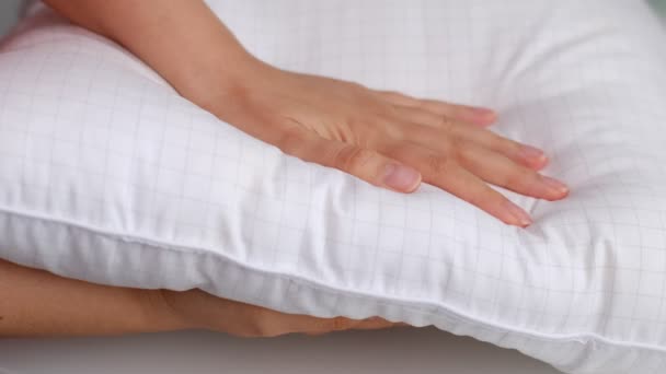 Young woman touching soft white pillow, closeup. how to choose a pillow, artificial filling — Stock Video