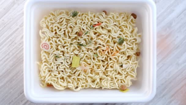Brewing noodles. Spices for instant noodles fall from top to bottom into the container with the product. Close-up shooting stock footage. slow motion — Stock Video