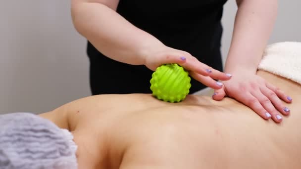 Mujer en la fisioterapia recibiendo masaje de bola de terapeuta. Un quiropráctico cura a los pacientes en el consultorio médico. Neurología, Osteopatía, quiropráctica — Vídeos de Stock