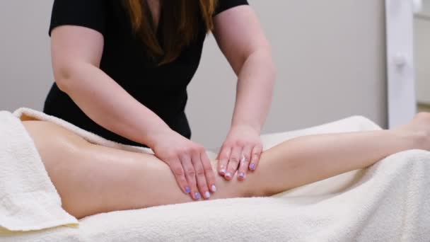 Masseur maakt anticellulite massage jonge vrouw in de spa salon. Speciale anti-cellulitis behandeling. Massage benen van jonge vrouw in spa salon. Lichaamsverzorging in spa salon voor jonge vrouw — Stockvideo