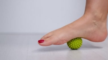 Ayak masajı topuna basmak Plantar fasiiti ya da topuk ağrısını dindirmek için. Kırmızı pedikürlü bir kadın. Ayağında tetik noktaları var.