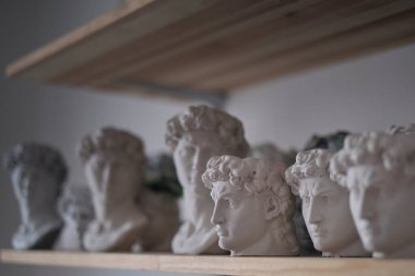 David 'in bir grup büstü bir rafta duruyor. Heykeltraşların çalışma alanı. Antika alçı büstleri