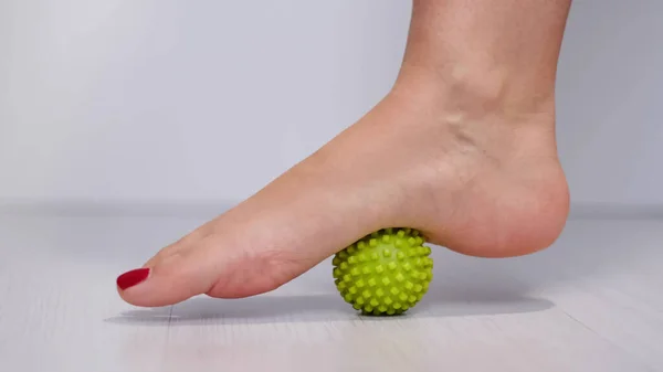 Foot step on massage ball to relieve Plantar fasciitis or heel pain. woman with red pedicure massaging trigger points on her foot — Φωτογραφία Αρχείου