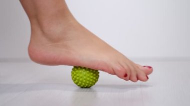 Ayak masajı topuna basmak Plantar fasiiti ya da topuk ağrısını dindirmek için. Kırmızı pedikürlü bir kadın. Ayağında tetik noktaları var.