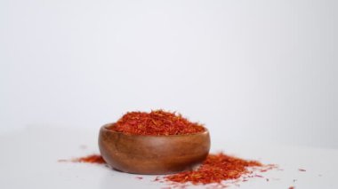 Ahşap safran kasesi kendi etrafında dönüyor. Ahşap tabakta beyaz arka planda izole edilmiş safran iplik. Stok görüntüleri. yavaş çekim.