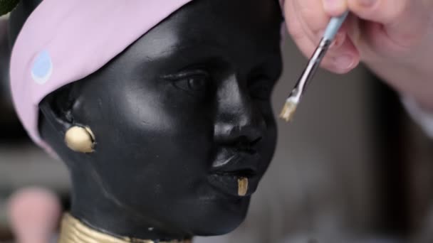 Femme décore un vase sous la forme d'un buste en plâtre. Buste de femme afro-américaine. pots pour fleurs en forme de tête de femme. foyer doux — Video