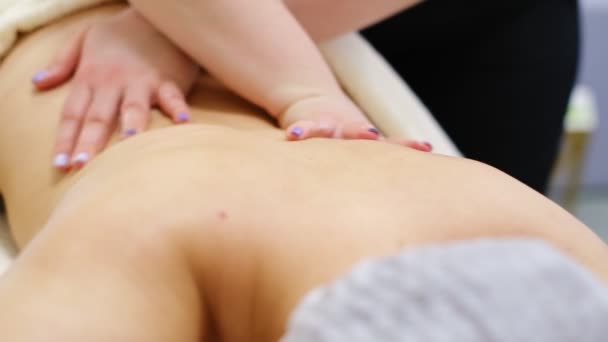 Primer plano masajista manos relajante o revitalizante procedimiento de masaje en el spa salón de belleza mujer agradable tumbado en el sofá disfrutando de la piel y el cuidado del cuerpo — Vídeos de Stock