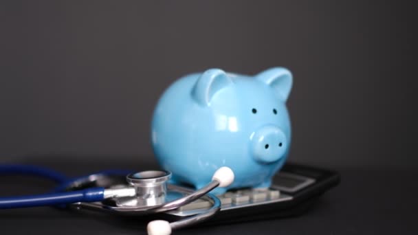 Stethoskop, Schweinepigmentrechner auf einem Tisch. präsentiert in der medizinischen Behandlung Gesundheitsuntersuchung oder Abbildung, Darstellung der medizinischen Kosten. — Stockvideo