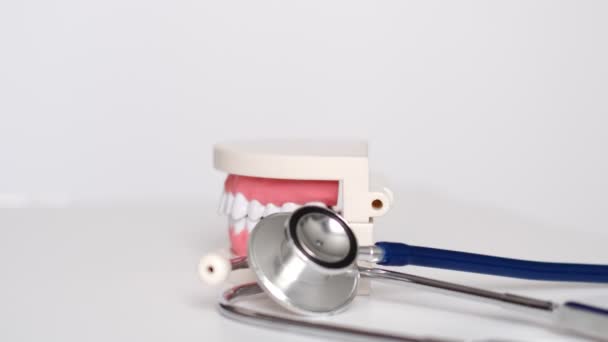 White teeth model and stakescope on white background. teeth care. concept of preventive examination of the oral cavity. — Stock Video