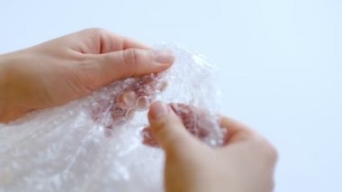 ASMR, kadın stres atmak için plastik balonlu naylona basıyor. Kabarcık paketi açılıyor