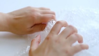ASMR, kadın stres atmak için plastik balonlu naylona basıyor. Kabarcık paketi açılıyor