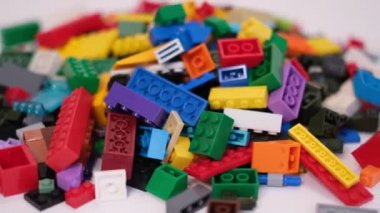 Plastik konteynırın üzerinde yatan çocuklar için renkli bir müteahhit. Pek çok renkli yapıcı parçası var. Kimlik konsepti. Beyaz arkaplanda plastik oyuncak blokları